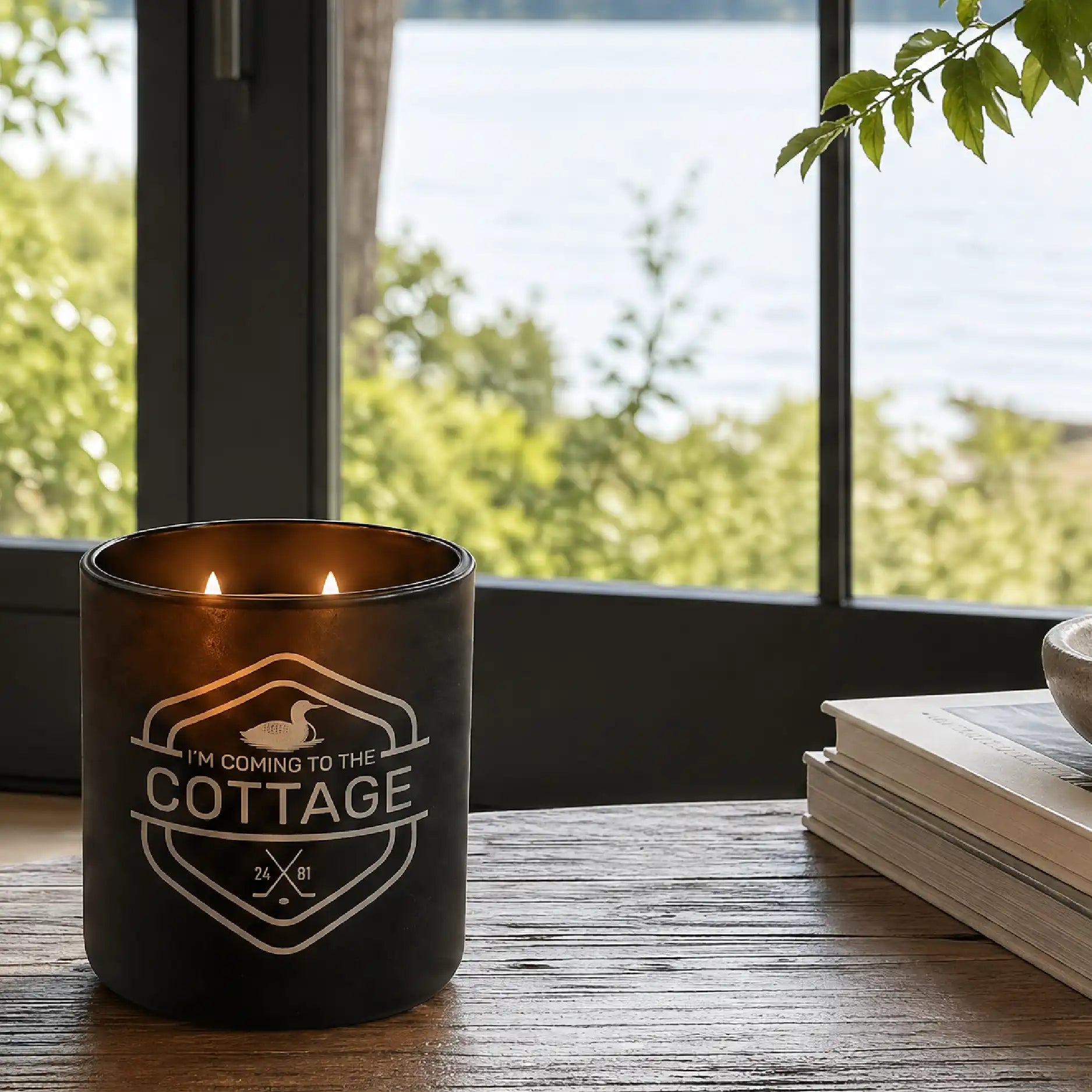 Wild Journey "I'm Coming to the Cottage" glowing candle on table with lake in background
